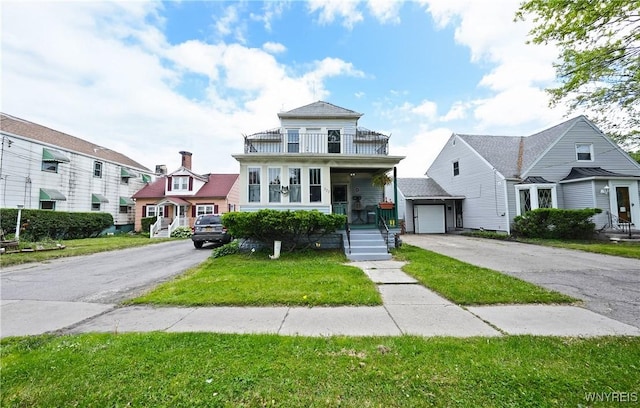 377 Pine Ridge Rd, Cheektowaga, NY 14225 - view of front of home with a balcony, driveway, covered porch, a front lawn, and a garage