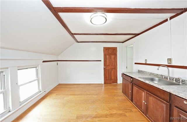 377 Pine Ridge Rd, Cheektowaga, NY 14225 - kitchen featuring light countertops, lofted ceiling, light wood-style floors, and brown cabinetry