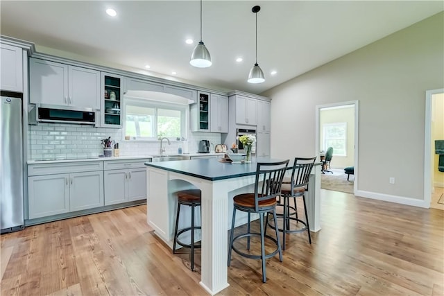 4338 State Route 90, Springport, NY 13160 - kitchen with appliances with stainless steel finishes, backsplash, a kitchen breakfast bar, vaulted ceiling, and a center island