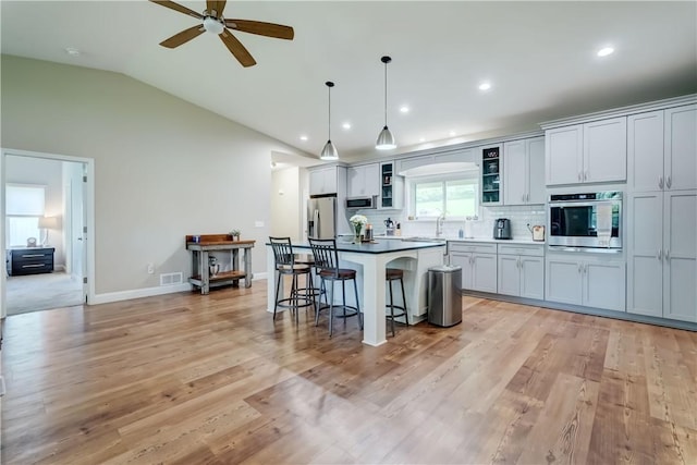 4338 State Route 90, Springport, NY 13160 - kitchen with stainless steel appliances, a kitchen bar, a kitchen island, lofted ceiling, and a ceiling fan