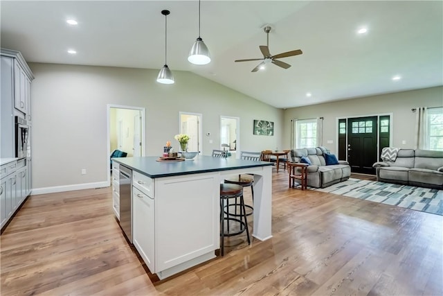 4338 State Route 90, Springport, NY 13160 - kitchen with dark countertops, a kitchen breakfast bar, ceiling fan, open floor plan, and healthy amount of natural light
