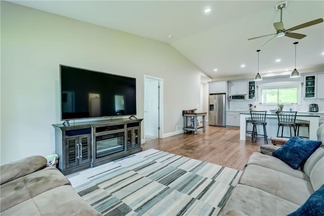 4338 State Route 90, Springport, NY 13160 - living room with vaulted ceiling, ceiling fan, light wood-style floors, and recessed lighting