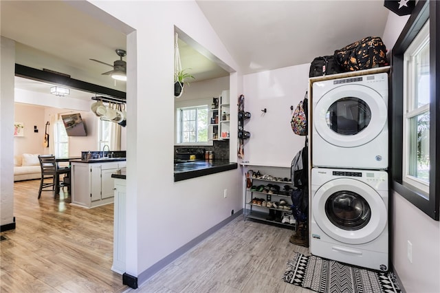 3839 Thompson Ave, Castile, NY 14549 - laundry room with stacked washing machine and dryer, a ceiling fan, and light wood-type flooring