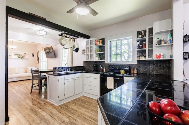 3839 Thompson Ave, Castile, NY 14549 - kitchen featuring black electric range oven, open shelves, a peninsula, white cabinetry, and decorative backsplash