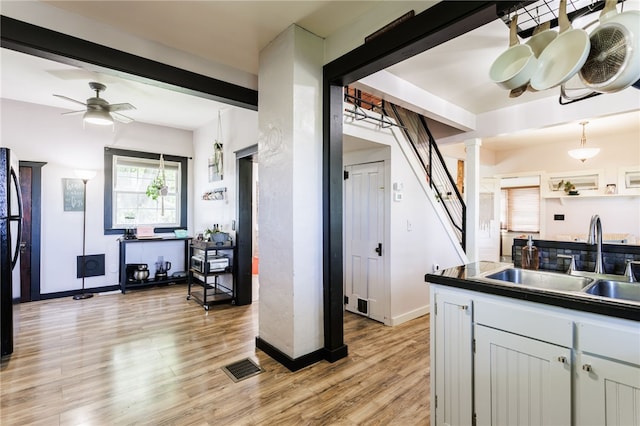 3839 Thompson Ave, Castile, NY 14549 - kitchen featuring light wood-style flooring, ceiling fan, decorative columns, and dark countertops