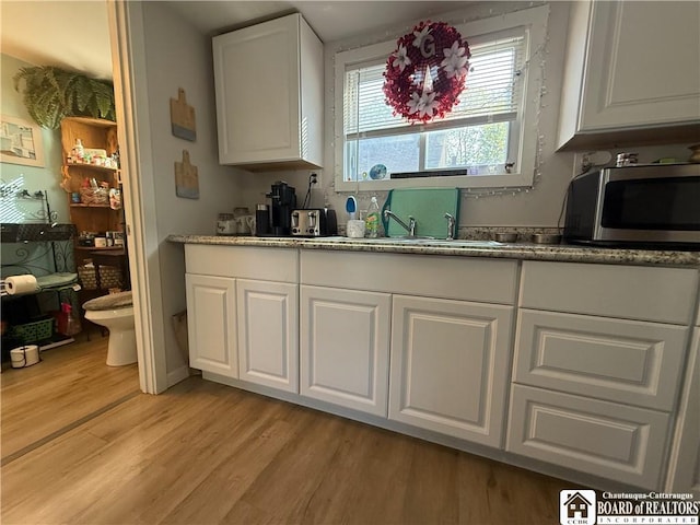 421 E Connell St, Olean-City, NY 14760 - kitchen featuring stainless steel microwave, light wood-style flooring, and white cabinets