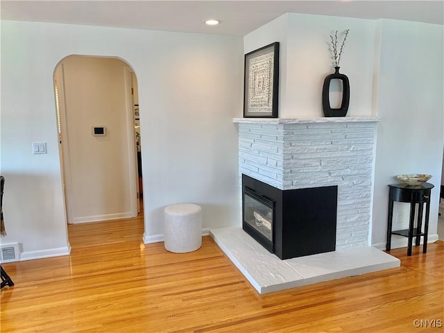 17 Benton Cir, New Hartford, NY 13501 - unfurnished living room with a glass covered fireplace, wood finished floors, arched walkways, and recessed lighting