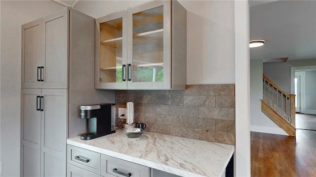 3228 County Road 28, Reading, NY 14891 - kitchen with backsplash, glass insert cabinets, wood finished floors, and light stone countertops