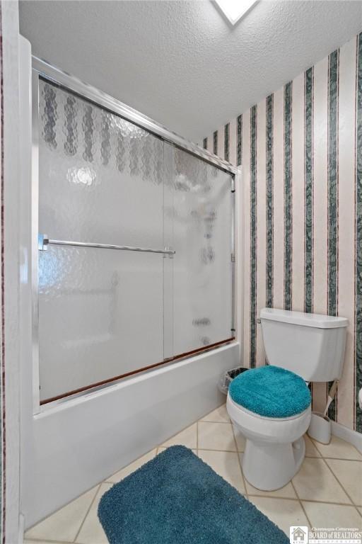 12 Ahrens Pl, Pomfret, NY 14063 - bathroom featuring tile patterned flooring, combined bath / shower with glass door, a textured ceiling, and wallpapered walls