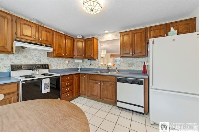 12 Ahrens Pl, Pomfret, NY 14063 - kitchen featuring white appliances, under cabinet range hood, brown cabinetry, light tile patterned flooring, and wallpapered walls