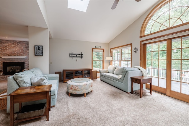 208 Blackwell Ln, Henrietta, NY 14467 - carpeted living room featuring a ceiling fan, a brick fireplace, high vaulted ceiling, and a skylight