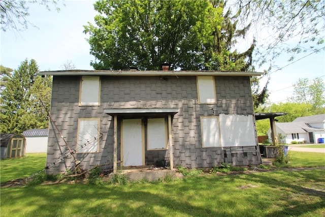 136 Knapp St, Albion, NY 14411 - back of house with a storage unit, a lawn, and a chimney