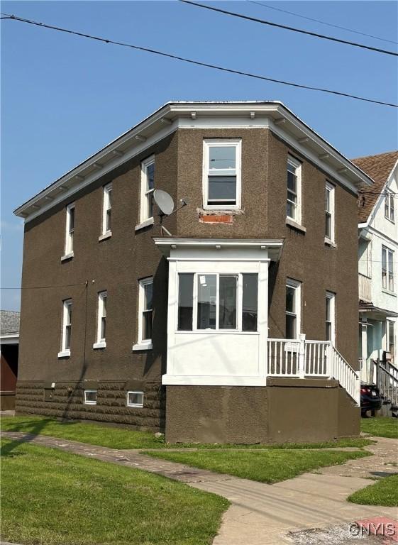918 Shaw St, Utica, NY 13502 - view of front facade with stucco siding and a front lawn