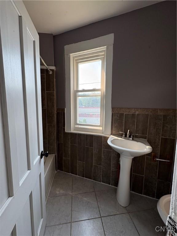 918 Shaw St, Utica, NY 13502 - full bathroom with tile walls, tile patterned flooring, wainscoting, and bathing tub / shower combination
