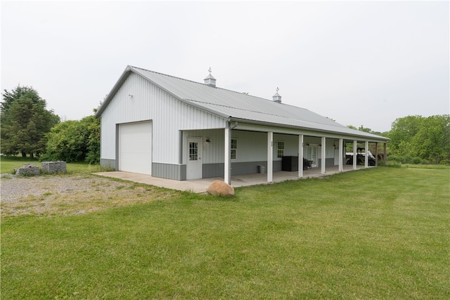 4582 Belwood Dr, Geneseo, NY 14454 - back of property featuring a lawn, a garage, driveway, a metal roof, and a patio