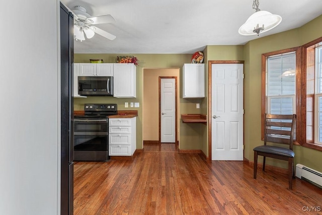 98 Krystyna Ln Unit 6, Cato, NY 13080 - kitchen with stainless steel microwave, black electric range oven, white cabinetry, a baseboard radiator, and dark wood finished floors