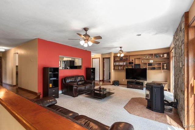 98 Krystyna Ln Unit 6, Cato, NY 13080 - living area featuring a ceiling fan, carpet floors, and a wood stove