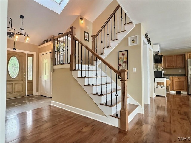 7530 Song Lake Rd, Preble, NY 13159 - foyer entrance with dark wood-style floors, a skylight, stairs, a wall mounted AC, and lofted ceiling