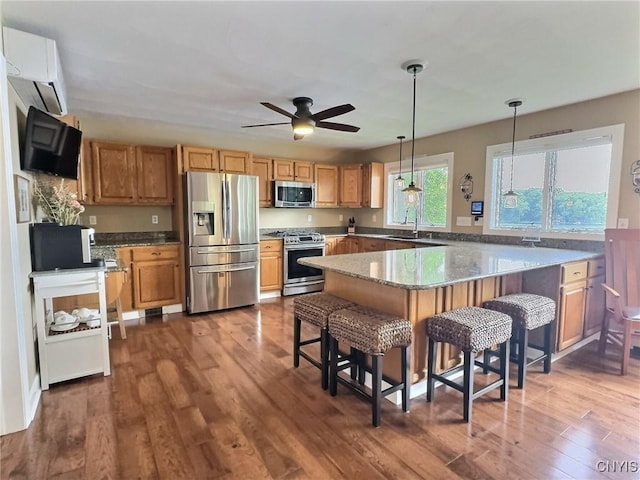 7530 Song Lake Rd, Preble, NY 13159 - kitchen with stainless steel appliances, a peninsula, a kitchen bar, dark wood-style flooring, and ceiling fan