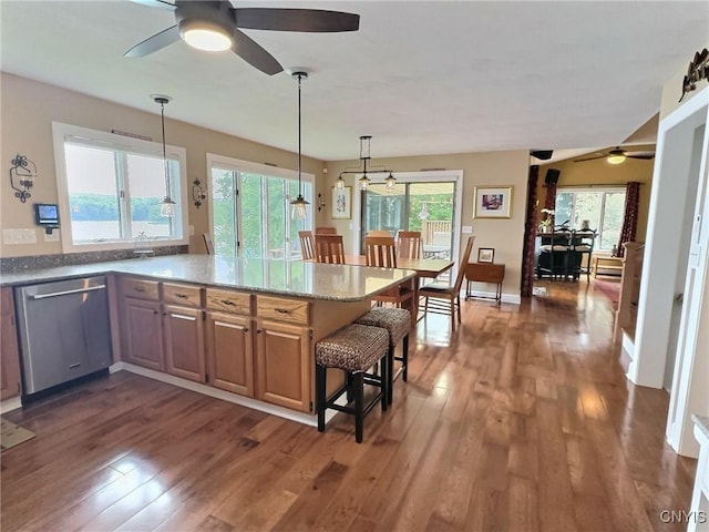 7530 Song Lake Rd, Preble, NY 13159 - kitchen with stainless steel dishwasher, a ceiling fan, dark wood-style flooring, light stone counters, and pendant lighting