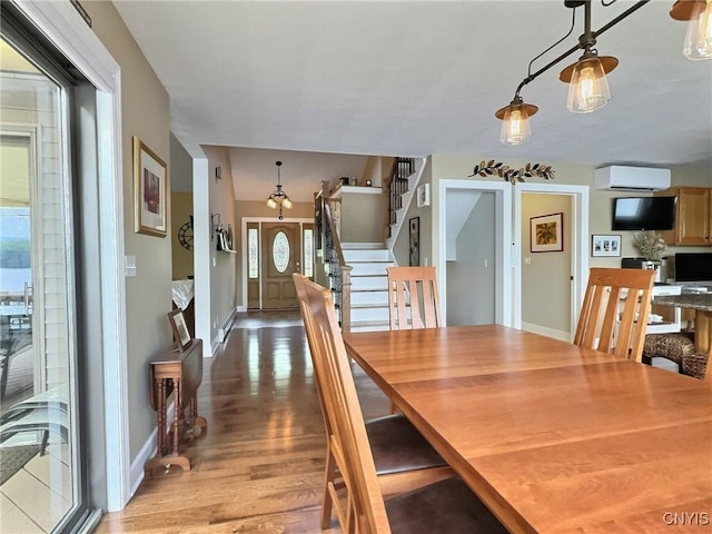 7530 Song Lake Rd, Preble, NY 13159 - dining area featuring a wall mounted air conditioner, light wood-style flooring, and stairway