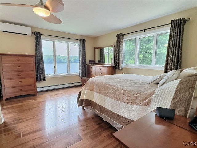 7530 Song Lake Rd, Preble, NY 13159 - bedroom with a wall mounted air conditioner, baseboard heating, wood finished floors, and ceiling fan