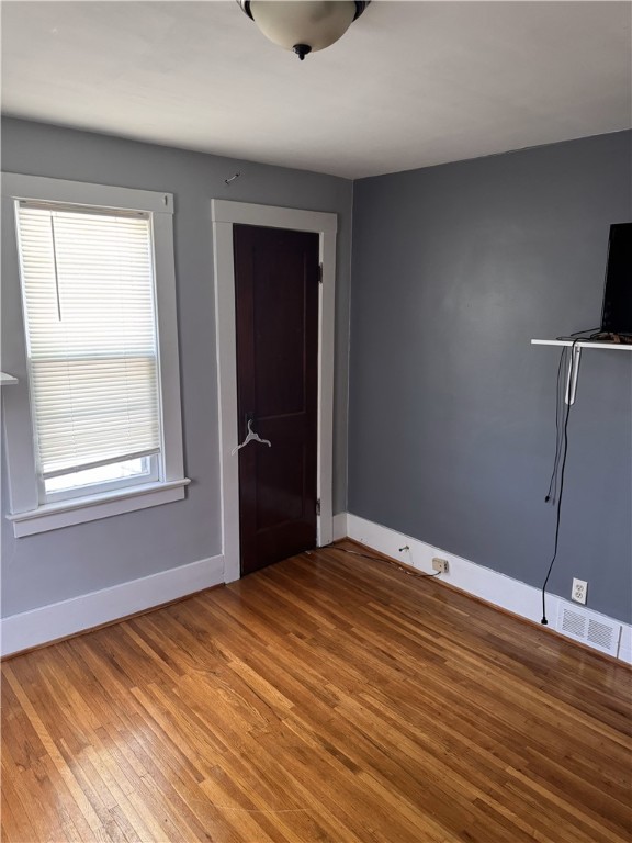 94 Wetmore Park, Rochester, NY 14606 - unfurnished bedroom featuring wood finished floors and multiple windows