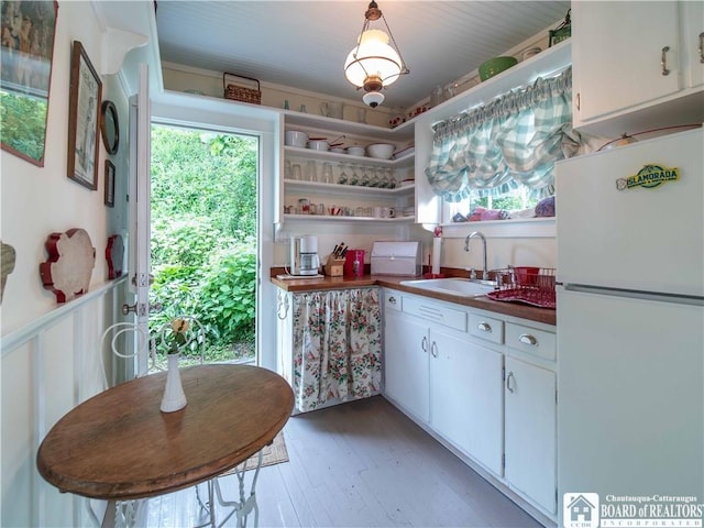4896 Ashville Bay Rd, North Harmony, NY 14710 - kitchen featuring freestanding refrigerator, white cabinetry, light wood-style floors, and plenty of natural light