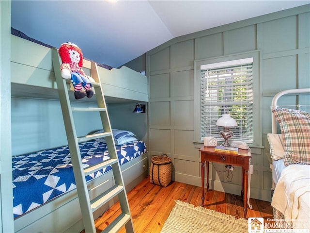 4896 Ashville Bay Rd, North Harmony, NY 14710 - bedroom featuring a decorative wall, hardwood / wood-style flooring, and lofted ceiling