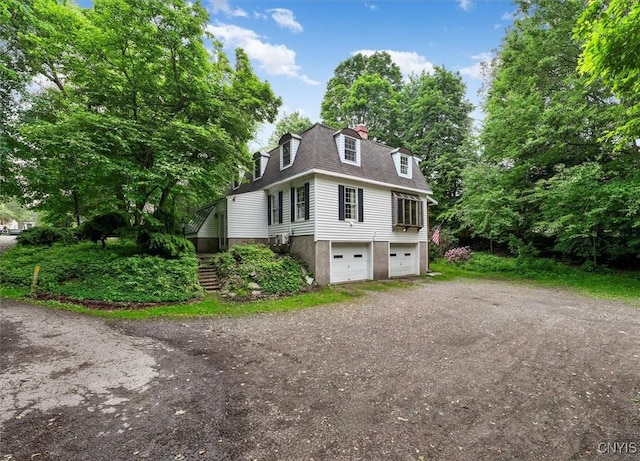 13 Dodd St, Whitestown, NY 13492 - view of front of home with driveway, an attached garage, stairs, a chimney, and a shingled roof