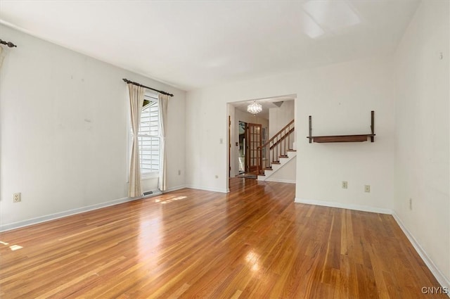 13 Dodd St, Whitestown, NY 13492 - unfurnished living room with light wood-type flooring, stairway, and a chandelier