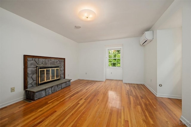 13 Dodd St, Whitestown, NY 13492 - unfurnished living room with a wall mounted AC, light wood-type flooring, and a fireplace