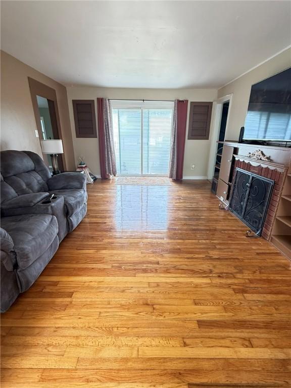 114 W Main St, Sidney, NY 13838 - living area with light wood-type flooring and a fireplace