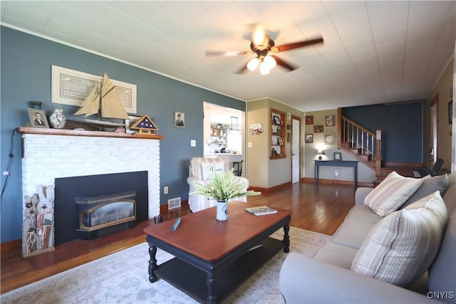 19536 State Route 3, Hounsfield, NY 13601 - living room with stairs, ceiling fan, wood finished floors, a brick fireplace, and crown molding