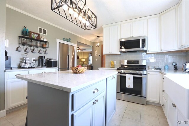 19536 State Route 3, Hounsfield, NY 13601 - kitchen with stainless steel appliances, light tile patterned floors, backsplash, crown molding, and white cabinetry