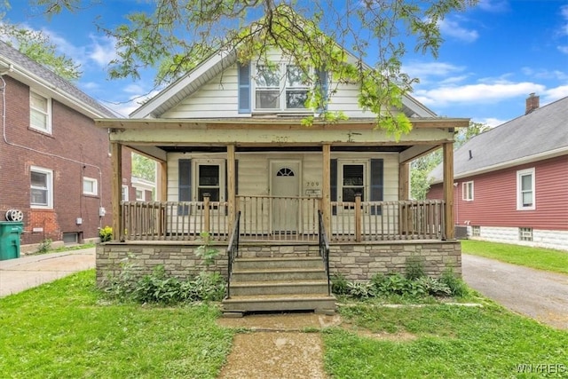 709 87th St, Niagara Falls, NY 14304 - bungalow-style house with covered porch and a front lawn