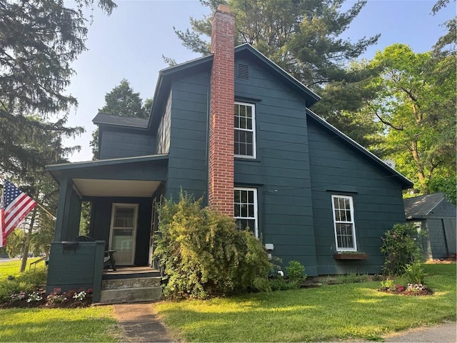 201 Sheppard St, Milo, NY 14527 - view of side of home with covered porch, a yard, and a chimney