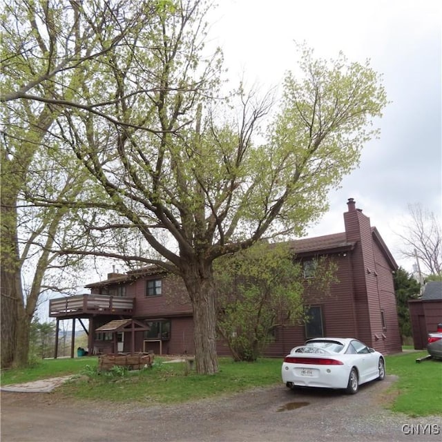 3903 Lafayette Rd, Lafayette, NY 13078 - view of front of house featuring a wooden deck, a chimney, driveway, and a front yard