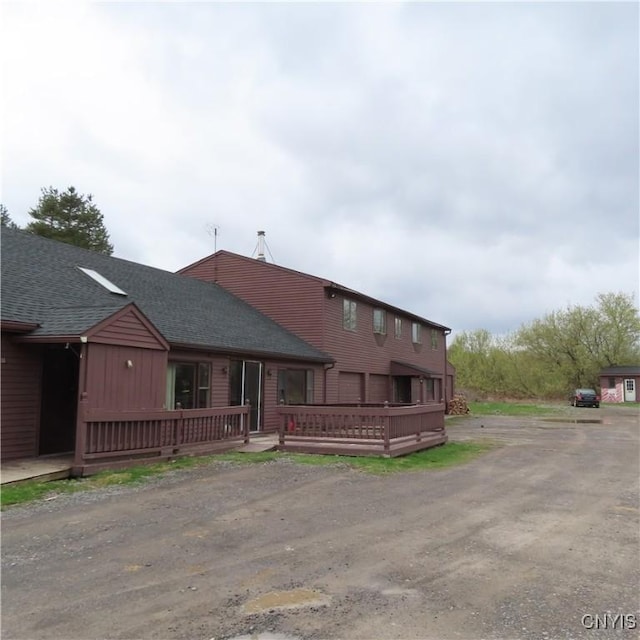 3903 Lafayette Rd, Lafayette, NY 13078 - view of front of property with a wooden deck, a shingled roof, and dirt driveway