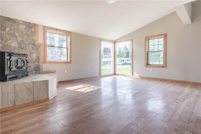 46946 Dingman Point Rd, Alexandria, NY 13607 - unfurnished living room with light wood-style floors, vaulted ceiling, and a wood stove