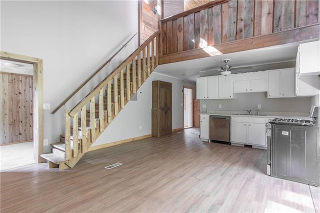46946 Dingman Point Rd, Alexandria, NY 13607 - kitchen with dishwasher, gas stove, light wood finished floors, light countertops, and white cabinets