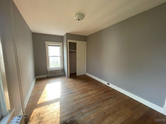 551/2 N Helmer Ave, Manheim, NY 13329 - unfurnished bedroom featuring radiator heating unit, wood finished floors, and a closet