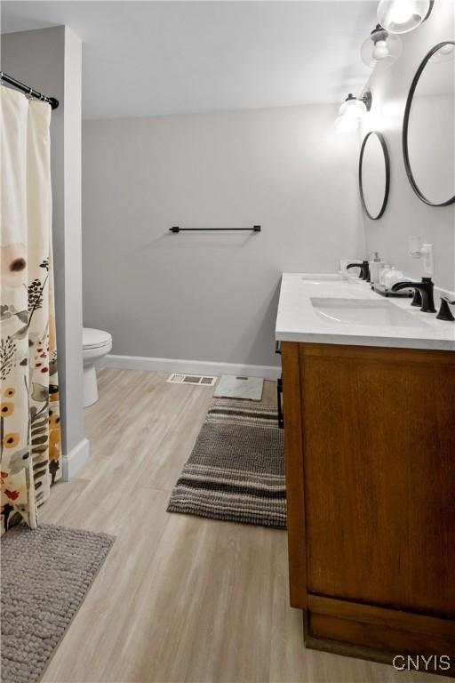 7698 Anchor Dr, Clay, NY 13090 - bathroom with vanity, wood finished floors, and a shower with shower curtain