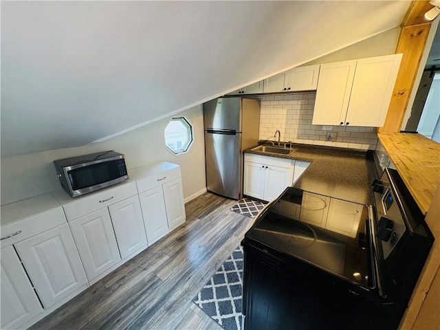 216 W William St Unit 201, Corning-City, NY 14830 - kitchen with appliances with stainless steel finishes, lofted ceiling, backsplash, white cabinets, and dark wood-style floors