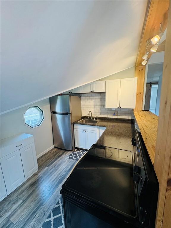 216 W William St Unit 201, Corning-City, NY 14830 - kitchen with freestanding refrigerator, tasteful backsplash, black electric range oven, dark wood-type flooring, and vaulted ceiling