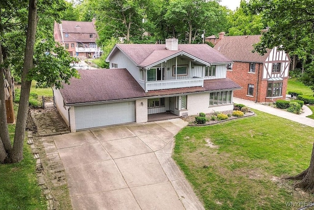 425 Vanderbilt Ave, Niagara Falls, NY 14305 - view of front of home with concrete driveway, a balcony, a chimney, brick siding, and an attached garage
