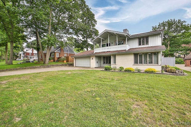 425 Vanderbilt Ave, Niagara Falls, NY 14305 - view of front facade with board and batten siding, asphalt driveway, a balcony, a garage, and brick siding
