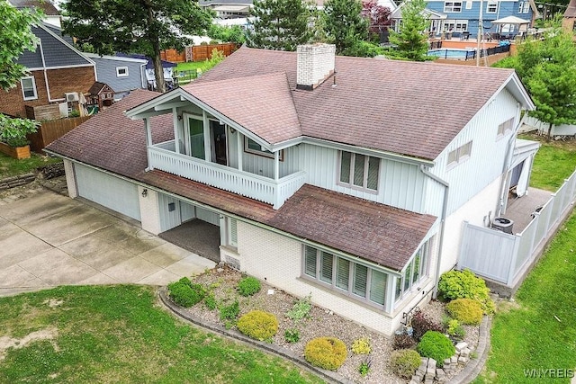 425 Vanderbilt Ave, Niagara Falls, NY 14305 - back of house featuring a chimney, concrete driveway, a residential view, and a shingled roof