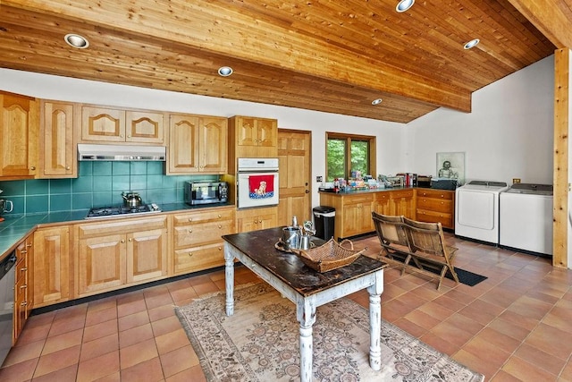 8 Small Rd, Middletown, NY 12455 - kitchen featuring stainless steel appliances, washer and clothes dryer, light tile patterned floors, under cabinet range hood, and decorative backsplash