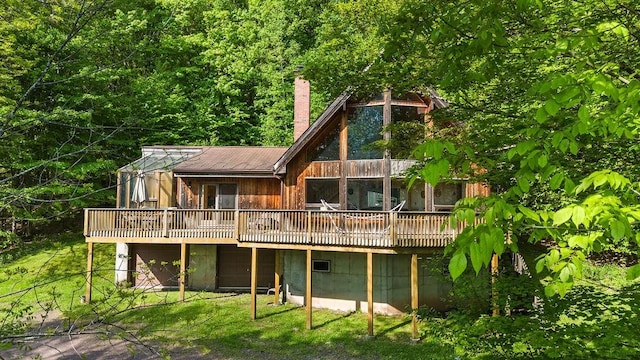 8 Small Rd, Middletown, NY 12455 - back of house with a chimney, a wooden deck, and a view of trees